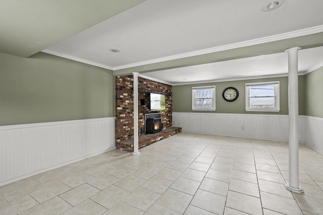 unfurnished living room with ornate columns, ornamental molding, and light tile patterned floors