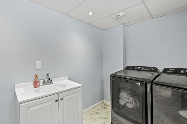 laundry area with cabinets, separate washer and dryer, and sink