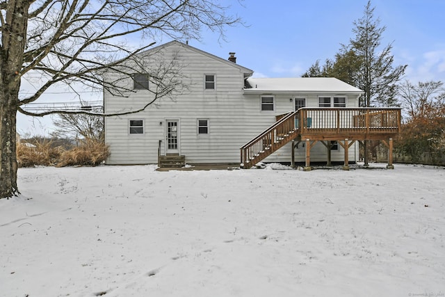 snow covered property with a deck