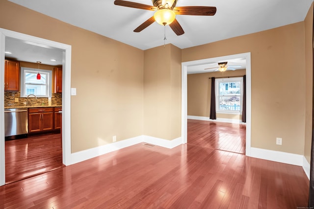 spare room featuring plenty of natural light, hardwood / wood-style floors, and ceiling fan