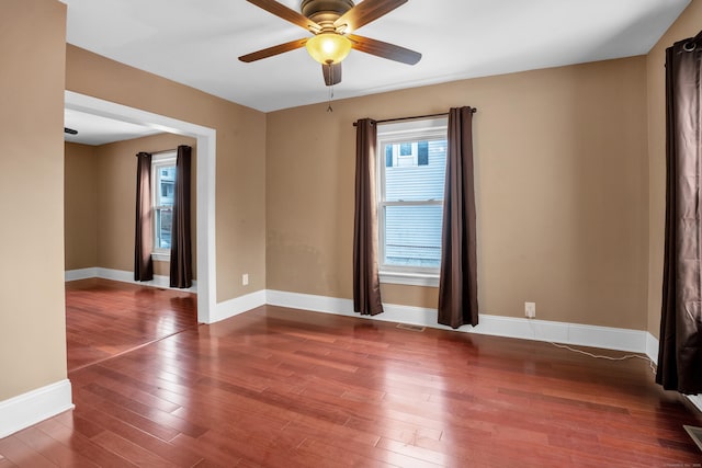 empty room with ceiling fan and dark hardwood / wood-style floors