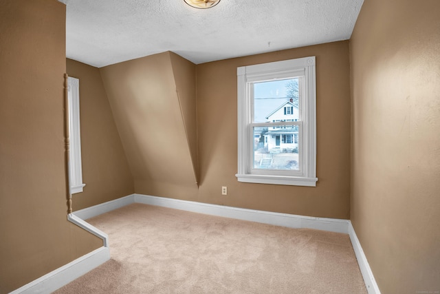 carpeted spare room with a textured ceiling