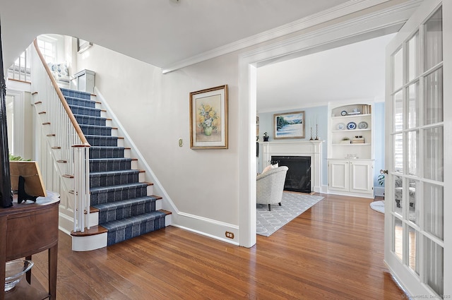 interior space featuring crown molding, hardwood / wood-style flooring, and plenty of natural light