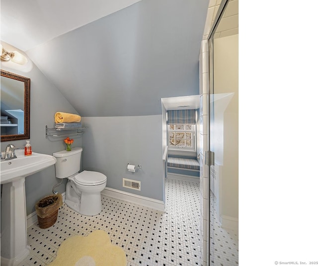 bathroom featuring vaulted ceiling, a shower with shower door, sink, and toilet