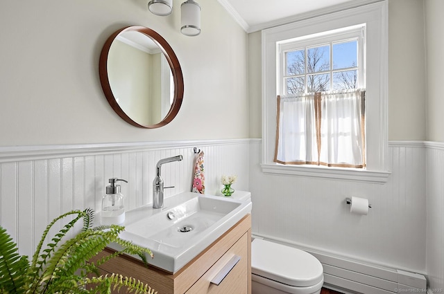 bathroom with vanity, a baseboard radiator, ornamental molding, and toilet