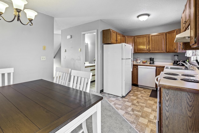 kitchen with an inviting chandelier, white appliances, sink, and a textured ceiling