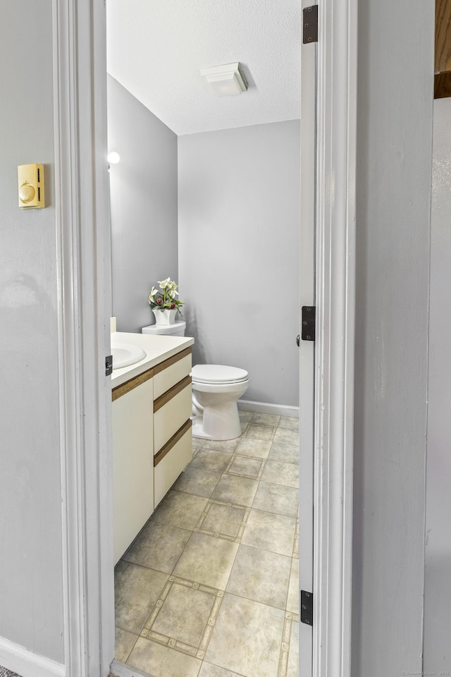 bathroom with vanity, a textured ceiling, and toilet