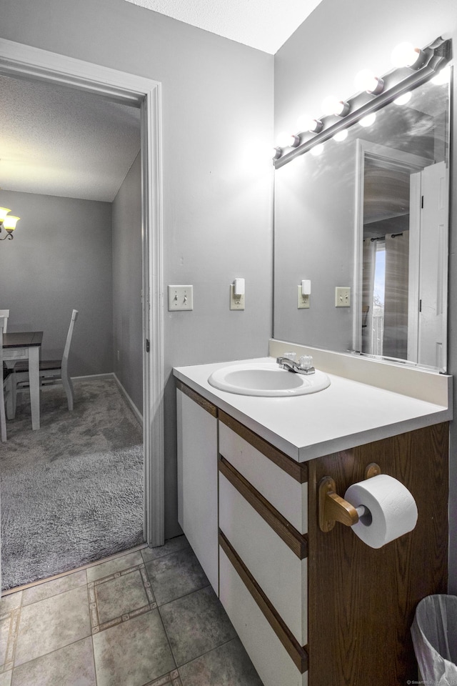 bathroom with vanity, a chandelier, and a textured ceiling