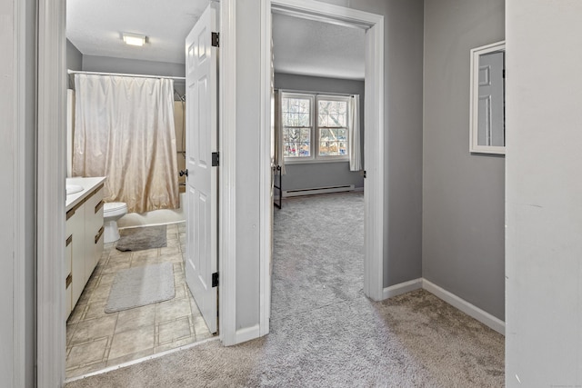 bathroom with walk in shower, toilet, a textured ceiling, baseboard heating, and vanity