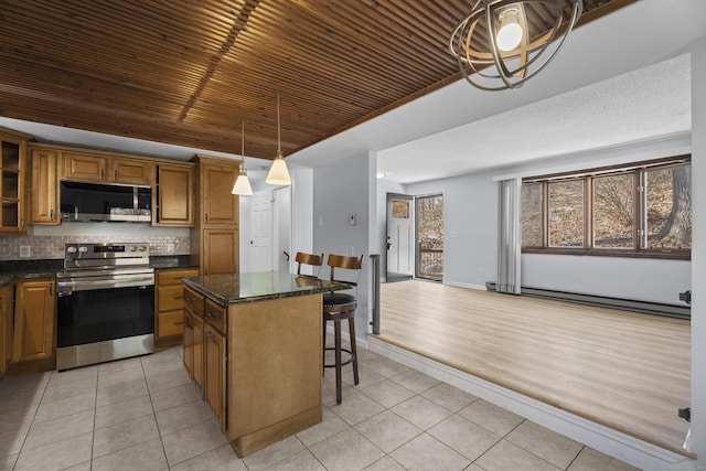 kitchen featuring light tile patterned flooring, stainless steel appliances, a center island, and hanging light fixtures