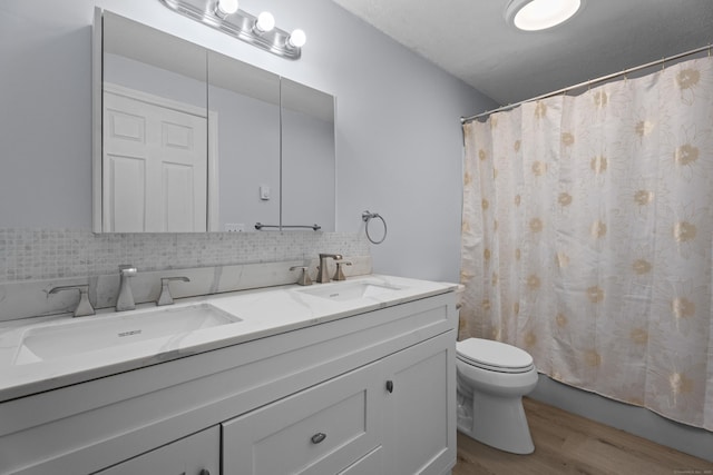 bathroom featuring vanity, backsplash, hardwood / wood-style flooring, and toilet