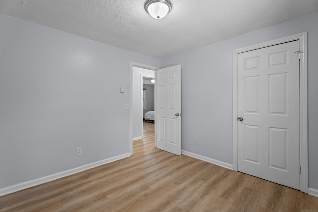 unfurnished bedroom featuring light hardwood / wood-style floors and a textured ceiling