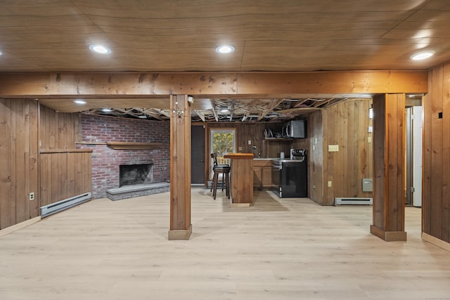 basement featuring a baseboard radiator, wooden walls, and light hardwood / wood-style floors