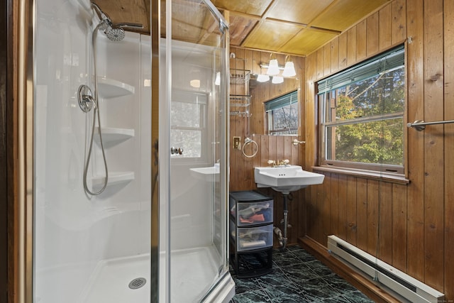 bathroom featuring baseboard heating, wooden walls, an enclosed shower, and sink