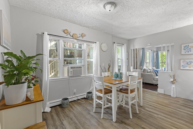 dining area with a baseboard radiator, hardwood / wood-style floors, a textured ceiling, and cooling unit