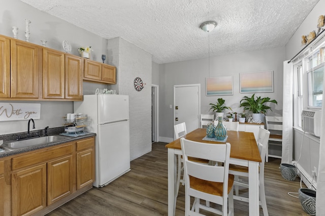 kitchen featuring dark wood-type flooring, sink, white fridge, and a textured ceiling