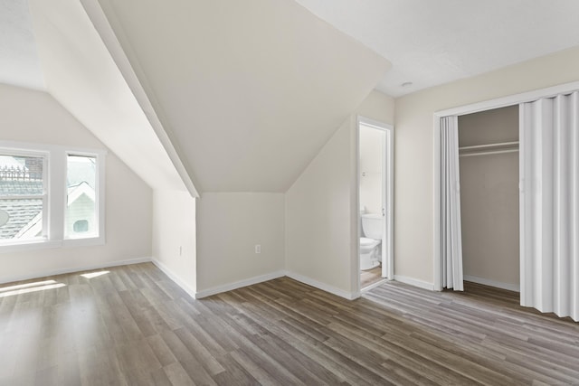 bonus room with wood-type flooring and vaulted ceiling