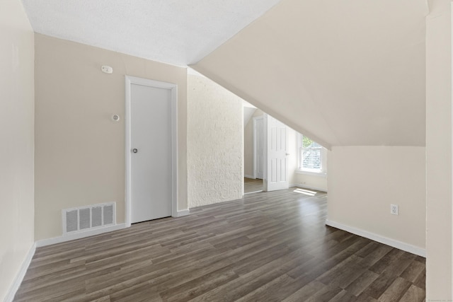 bonus room with vaulted ceiling and dark hardwood / wood-style flooring