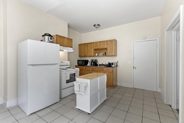 kitchen with a kitchen island, light tile patterned floors, and white appliances