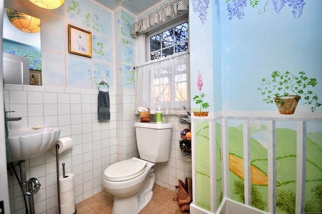 bathroom featuring toilet, tile patterned flooring, and tile walls