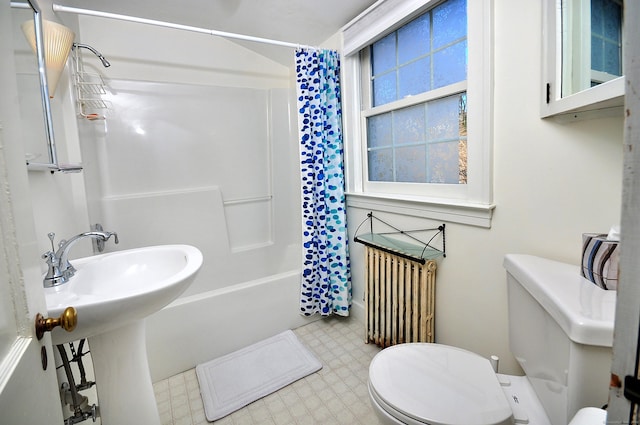 full bathroom featuring shower / bathtub combination with curtain, sink, radiator heating unit, and toilet