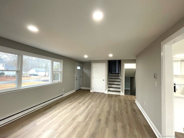 interior space featuring baseboard heating and light hardwood / wood-style floors