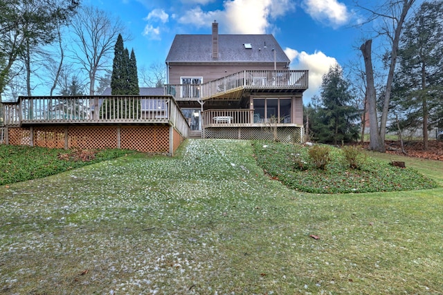 back of house with a wooden deck, a lawn, and a sunroom