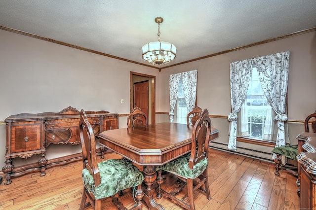 dining space with crown molding, a textured ceiling, light hardwood / wood-style flooring, a notable chandelier, and a baseboard heating unit