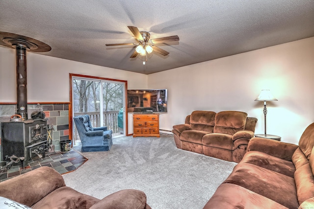 carpeted living room featuring a baseboard heating unit, a wood stove, a textured ceiling, and ceiling fan