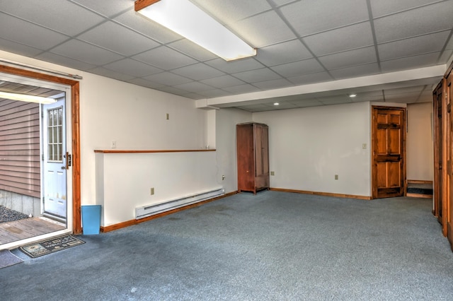 carpeted empty room featuring a drop ceiling and baseboard heating