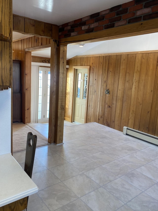 unfurnished room with a baseboard radiator and wooden walls