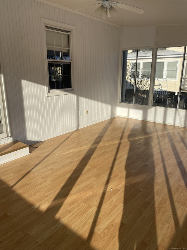 empty room with hardwood / wood-style flooring, crown molding, and ceiling fan