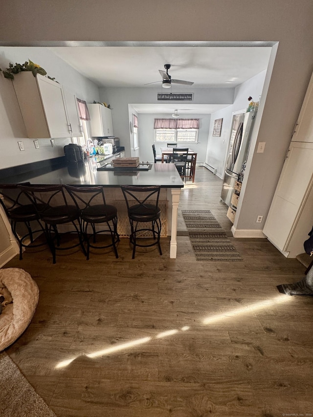 dining area with dark wood-type flooring and ceiling fan