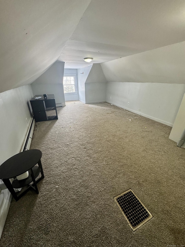 additional living space with dark colored carpet, lofted ceiling, and a baseboard radiator