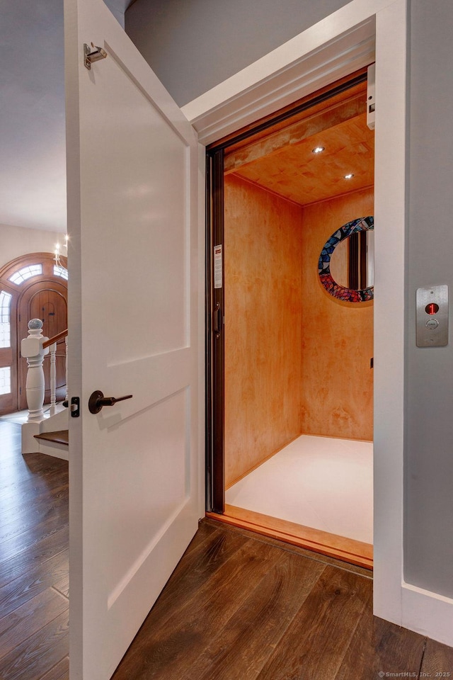 bathroom with hardwood / wood-style flooring and elevator