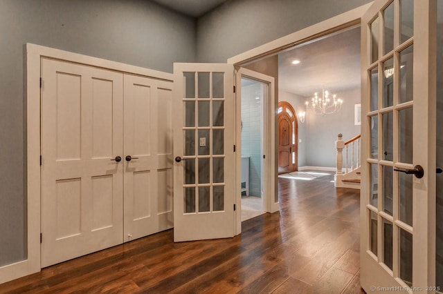 entryway featuring dark hardwood / wood-style floors, a notable chandelier, and french doors