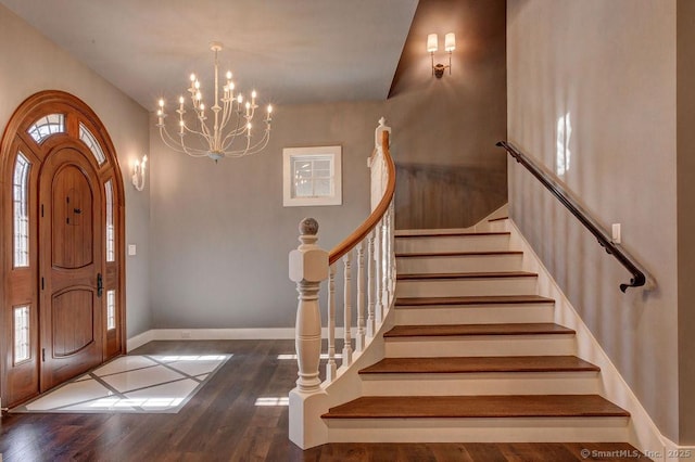 foyer entrance with dark wood-type flooring and a chandelier