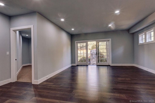 unfurnished room featuring dark wood-type flooring and a healthy amount of sunlight