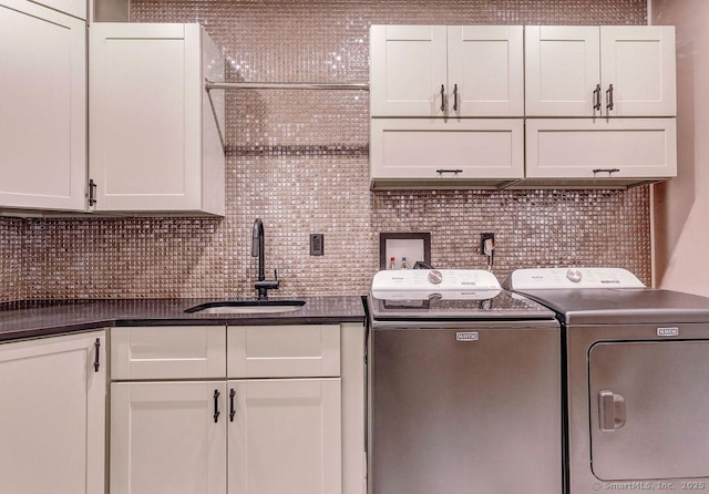 washroom featuring sink, cabinets, and washing machine and clothes dryer