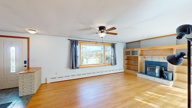 living room with hardwood / wood-style flooring, a baseboard radiator, ceiling fan, and a fireplace