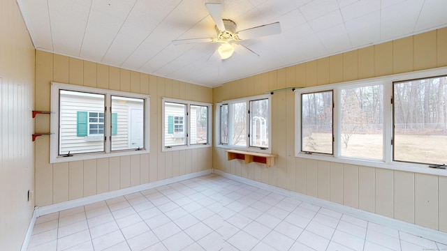 unfurnished sunroom featuring ceiling fan