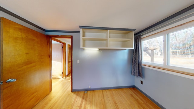 spare room featuring ornamental molding and light hardwood / wood-style floors