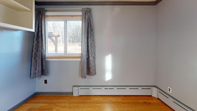 empty room featuring light hardwood / wood-style floors and baseboard heating