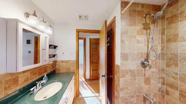 bathroom with vanity and tiled shower