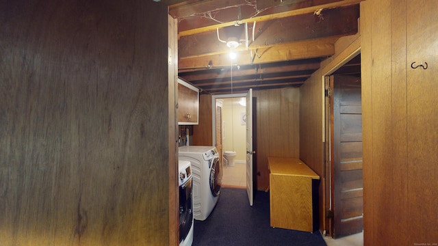 washroom featuring washing machine and clothes dryer and wooden walls