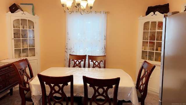 dining space featuring carpet flooring and a notable chandelier