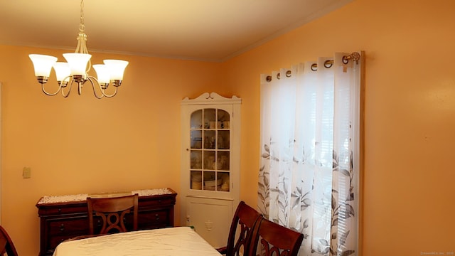 dining space with ornamental molding and a chandelier