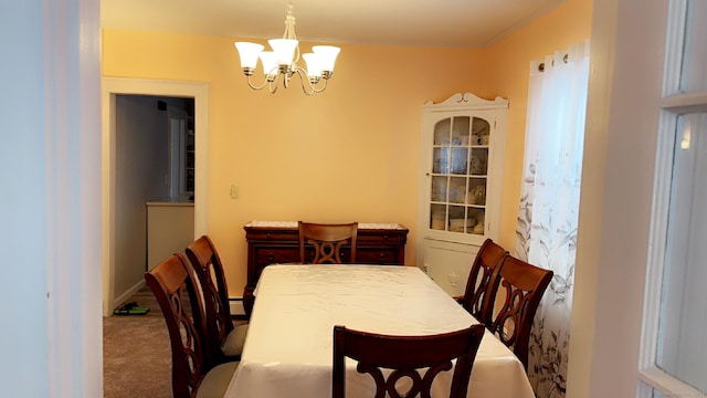 dining room featuring ornamental molding, carpet, and an inviting chandelier