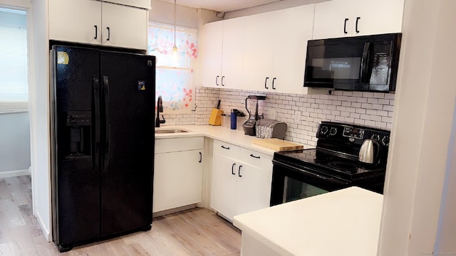 kitchen with sink, white cabinets, decorative backsplash, light hardwood / wood-style floors, and black appliances