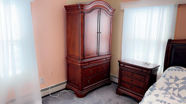 bedroom with light carpet and baseboard heating